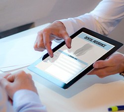 Patient reviewing dental insurance forms on tablet