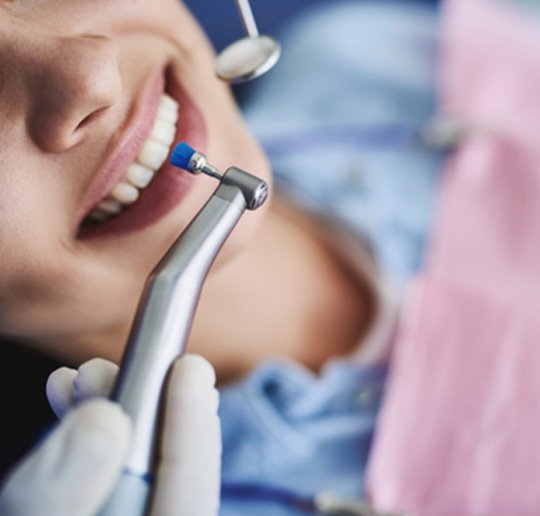 A close-up of a woman getting her teeth professionally cleaned