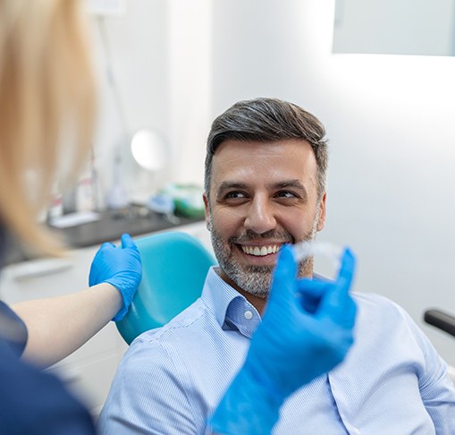 A patient smiling at dentist as they explain clear aligners