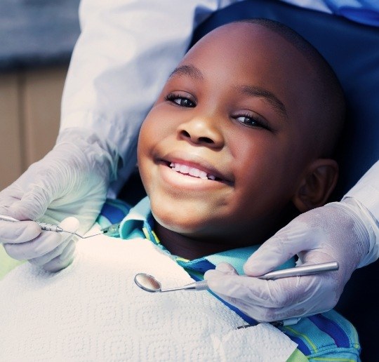 Child receiving children's dentistry checkup and teeth cleaning