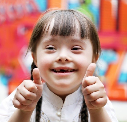 Little girl giving thumbs up after special needs dentistry