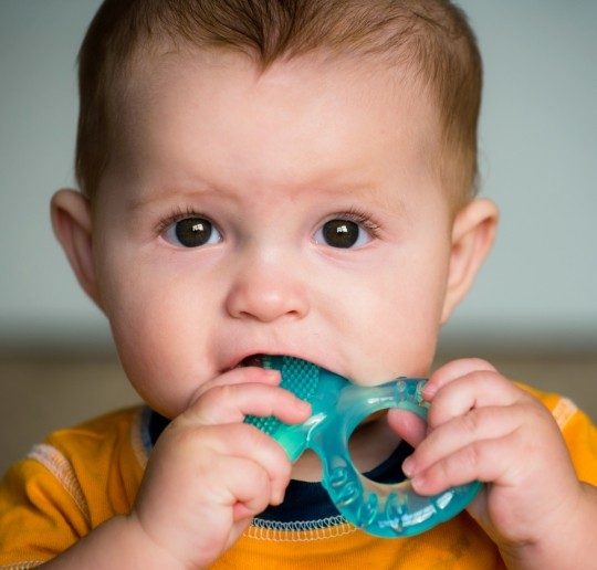 Child chewing on teething ring