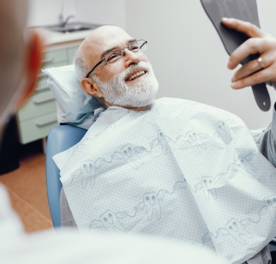 Man looking at smile after denture placement