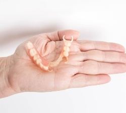 Hand holding partial denture