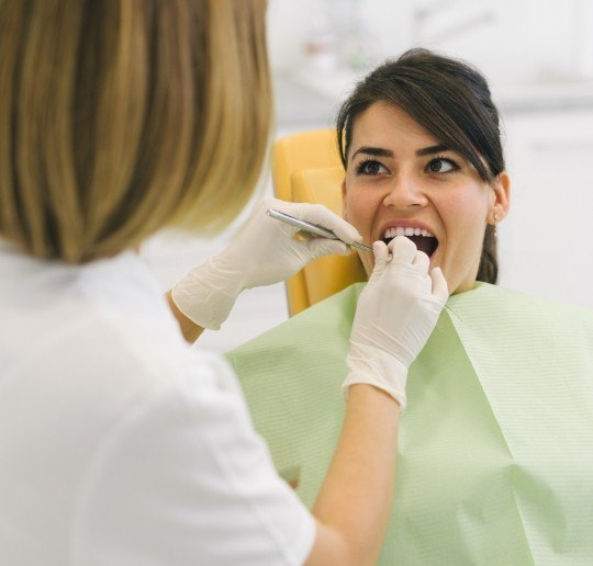 Woman receiving dental checkup to prevent dental emergencies