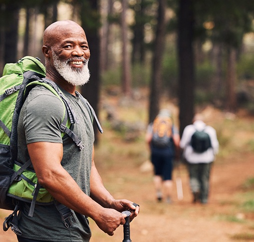 Bearded man smiling while hiking outside