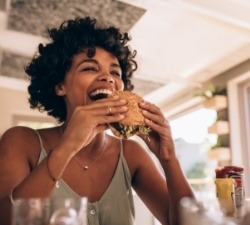 Woman enjoying dinner after dental implant tooth replacement