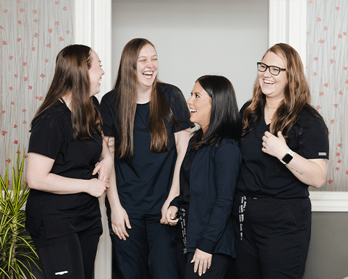 Dental team member and patient laughing together