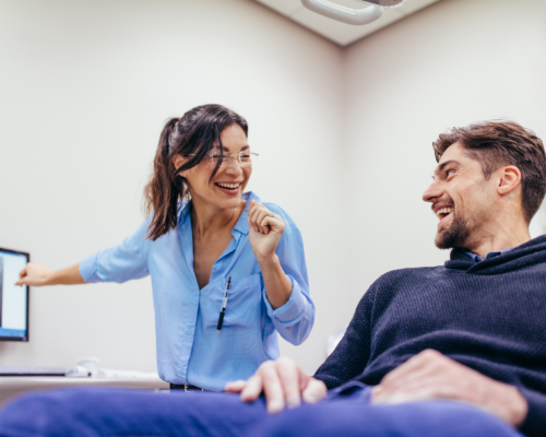 Dental team member and patient laughing together