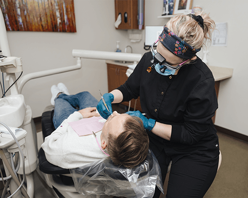 Smiling woman in dental chair talking to dentist