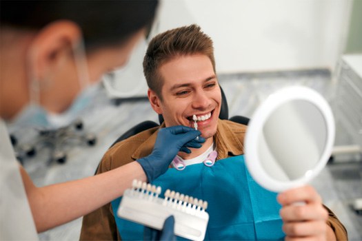 Patient admiring smile in dental mirror