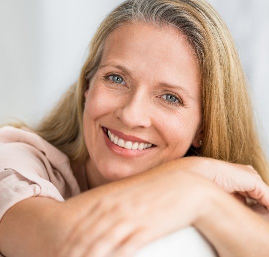 Woman sharing healthy smile after replacing missing teeth with dental bridges