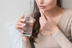 a woman taking an oral conscious sedation pill