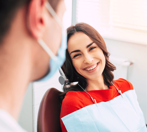 Woman in dental chair smiling at dentist