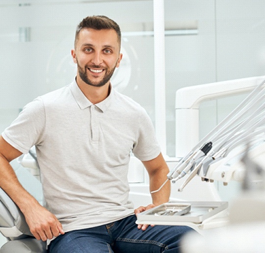 Man sitting up and smiling after oral cancer screening in Gahanna, OH