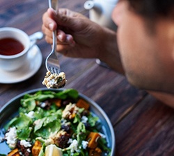 Closeup of man having a salad and cup of tea