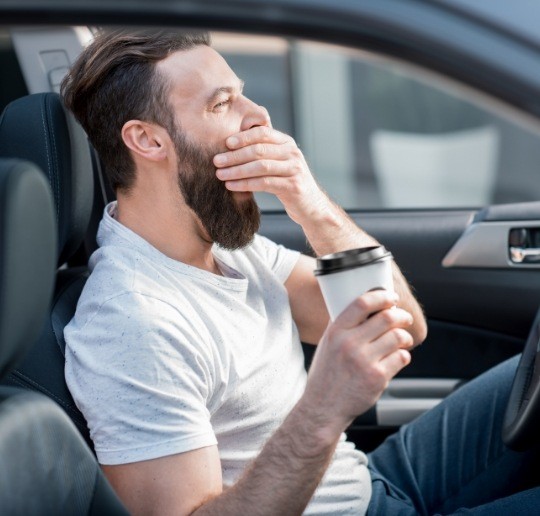 Man driving feeling tired due to untreated sleep apnea