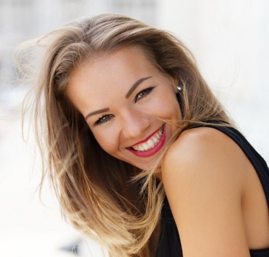 Woman sharing flawless smile after porcelain veneers