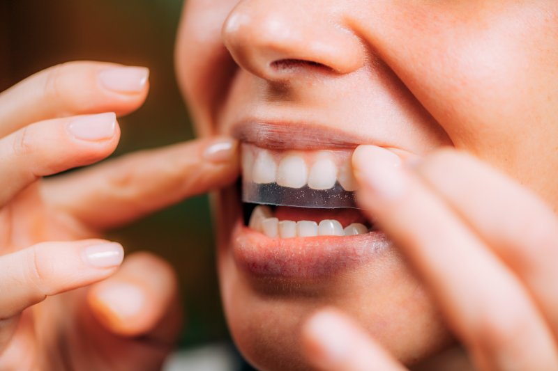 person using teeth whitening strips in Gahanna