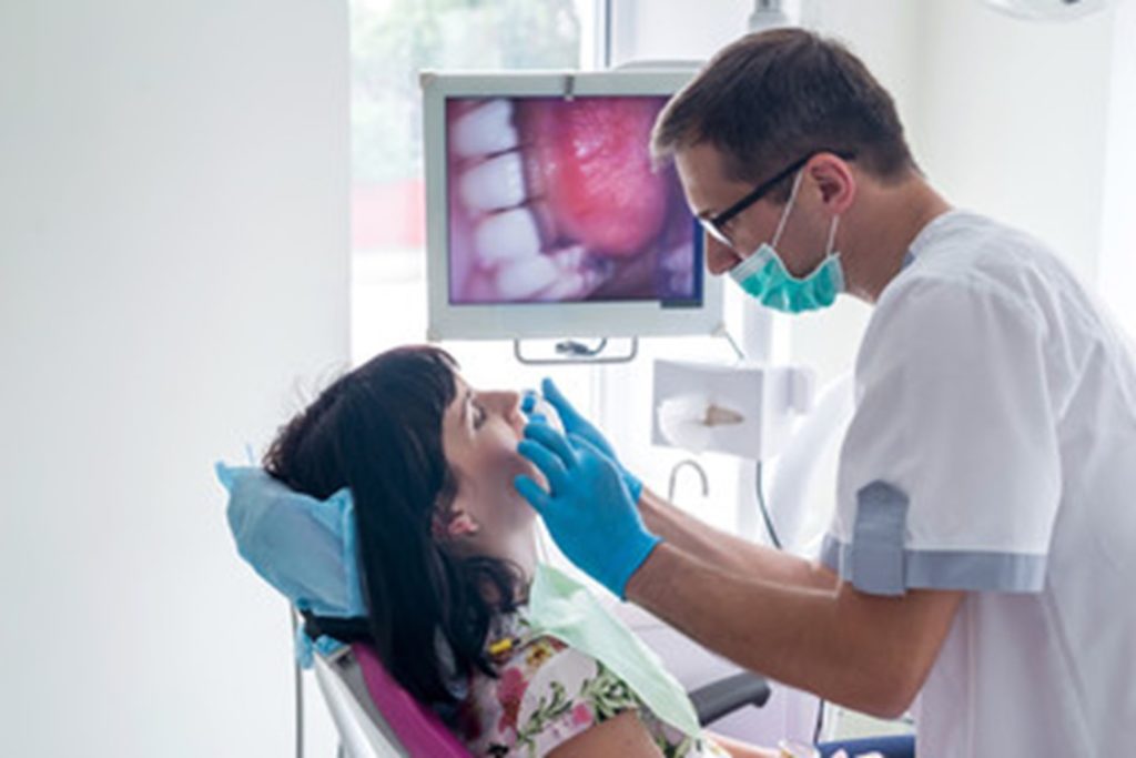 dentist using an intraoral camera during a dental exam