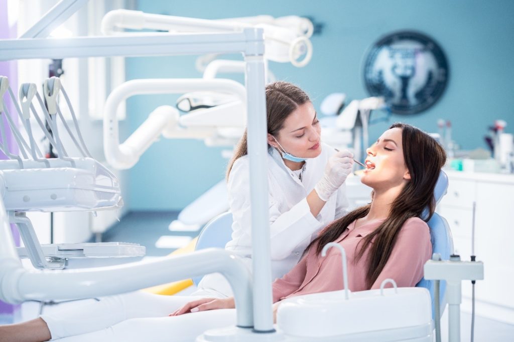 smiling dentist performing checkup
