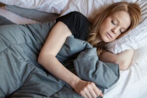 Woman sleeping peacefully under a weighted blanket