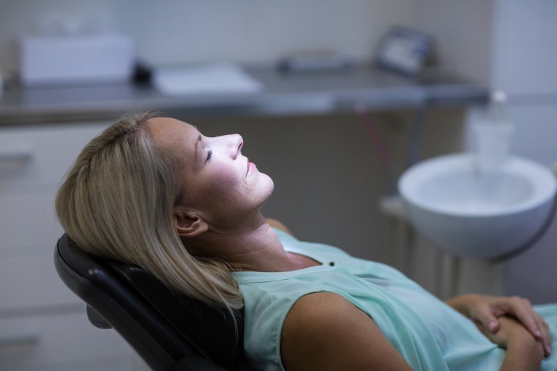 woman with her eyes closed in a treatment chair