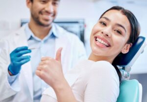 Happy dental patient making thumbs-up gesture