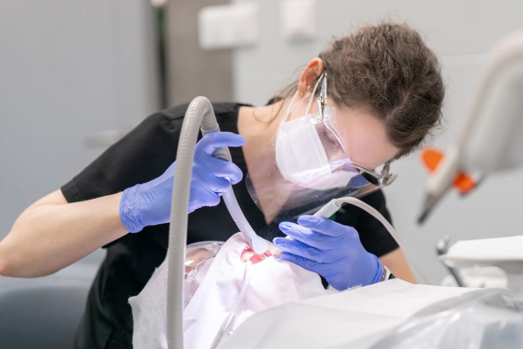 A dental hygienist using an air polisher